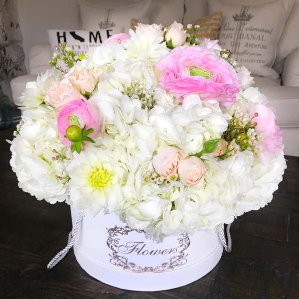 Round bouquet of white and pink flowers in a white hatbox