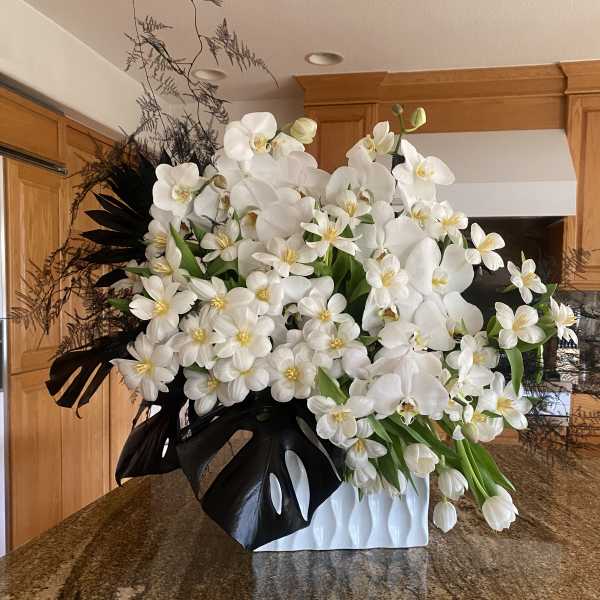 White orchid and tulip arrangement in a white vase