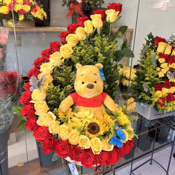 Large rose arrangement with a Winnie the Pooh plush and yellow flowers