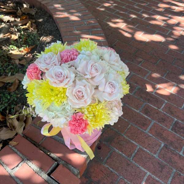 Bouquet of pale pink roses and yellow chrysanthemums tied with ribbon