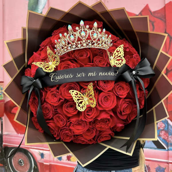 Large bouquet of red roses with a crown and black ribbon