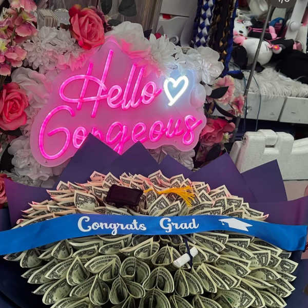 Money bouquet with a pink neon "Hello Gorgeous" sign and flowers