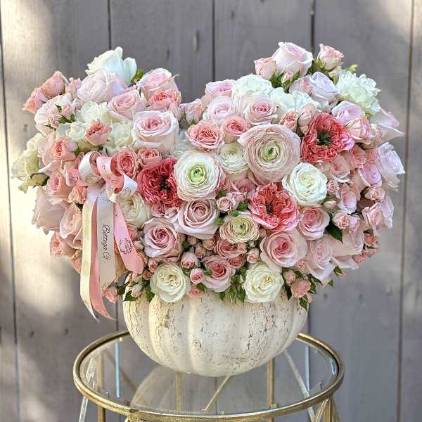 Large pastel bouquet of roses and ranunculus in a white vase