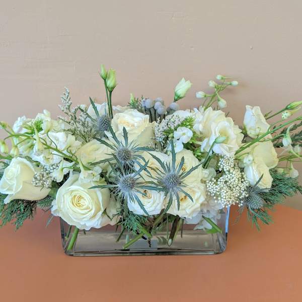 White rose arrangement in a rectangular glass vase