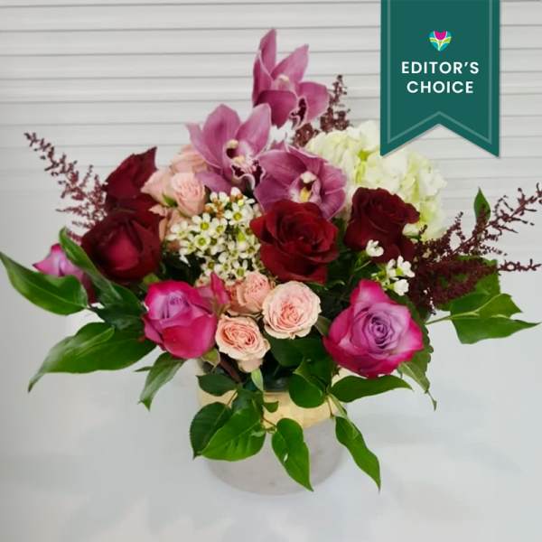 Bouquet of pink orchids and red roses in a vase