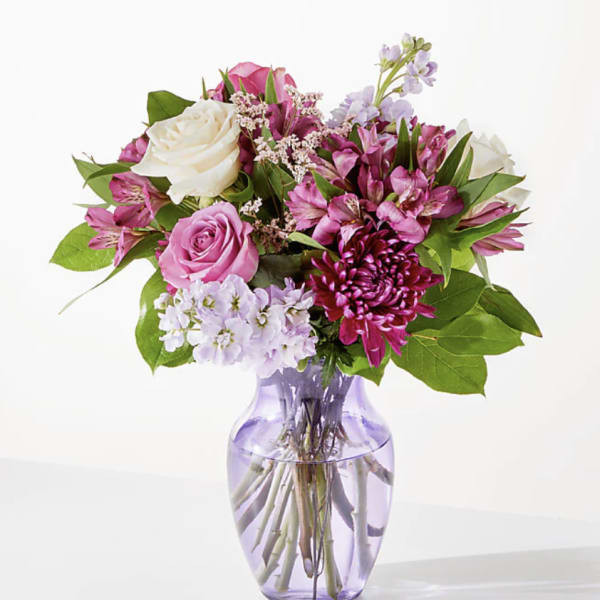 Pink and white mixed bouquet in a lavender glass vase