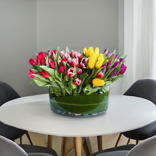 Colorful tulip arrangement in a clear glass bowl on a table