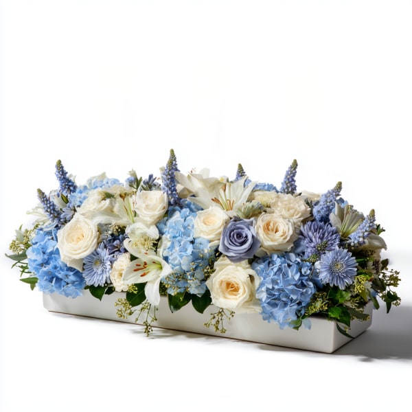 Blue and white floral arrangement in a rectangular white container