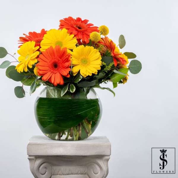 Bouquet of yellow and orange gerbera daisies in a glass vase