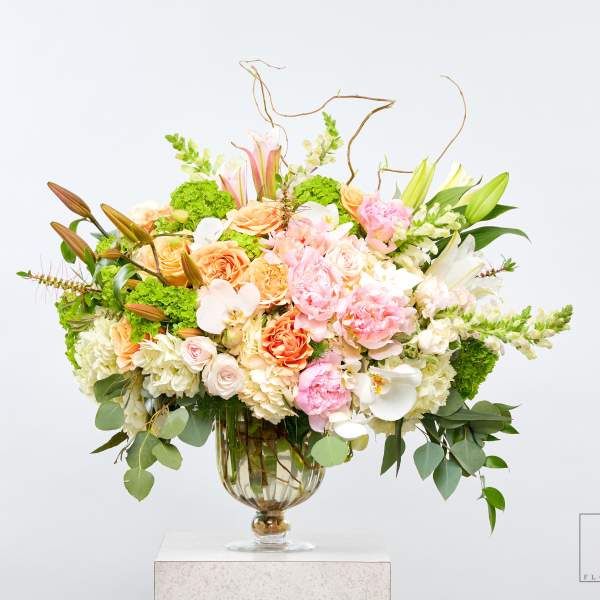 Large pastel floral arrangement in a glass vase