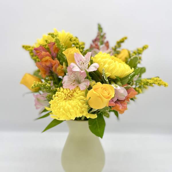 Yellow and pink mixed bouquet in a pale vase
