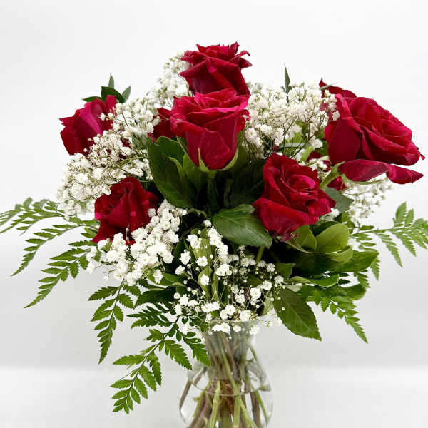 Red roses and white baby's breath in a clear glass vase