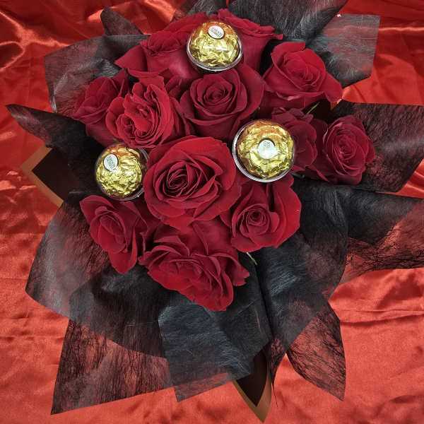 Red rose bouquet with gold-wrapped chocolates on black wrap