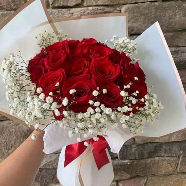 Bouquet of red roses with white baby's breath in white wrap