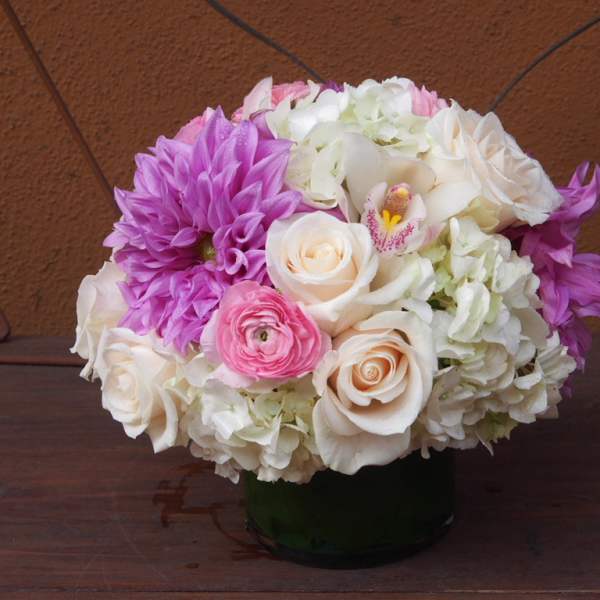 Pink, white, and purple flower arrangement in a dark vase