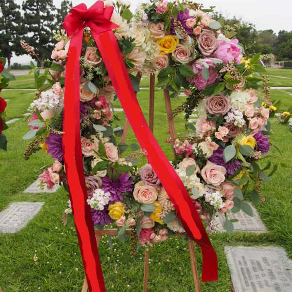 Floral wreath on a wooden easel with a red ribbon bow