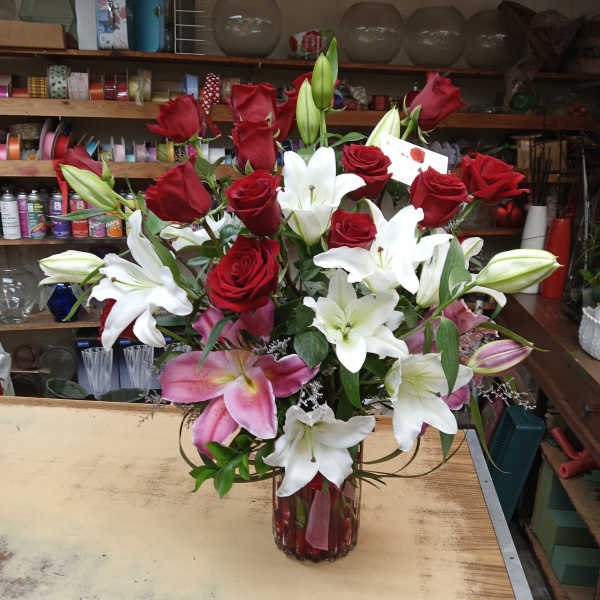 Red roses and white lilies arranged in a glass vase