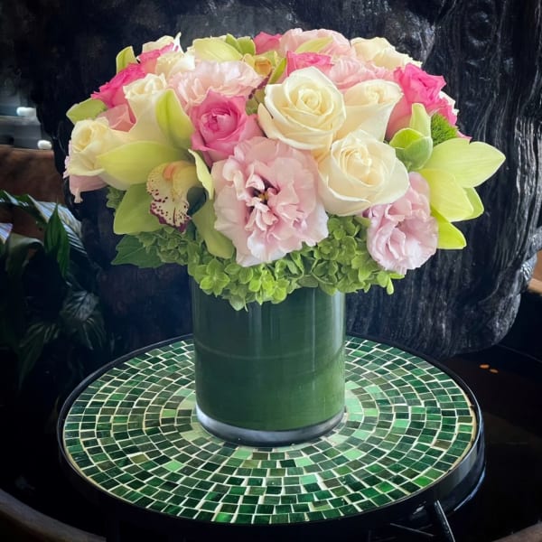 Pink and white rose bouquet in a green vase