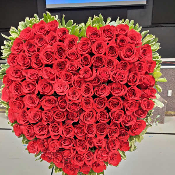 Heart-shaped arrangement of red roses on a stand