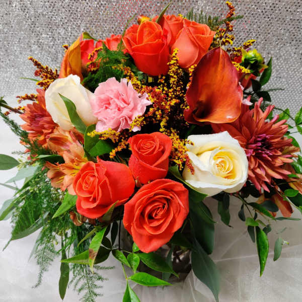 Bouquet of orange and white roses with pink flowers in a vase