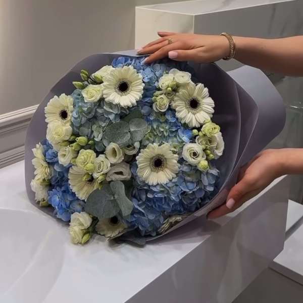 very beautiful bouquet with blue hydrangeas and gerberas