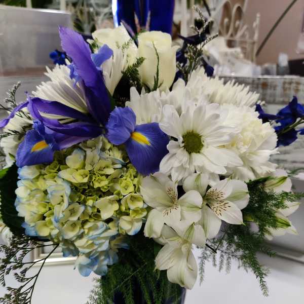 Blue and white mixed bouquet in a tall cobalt vase
