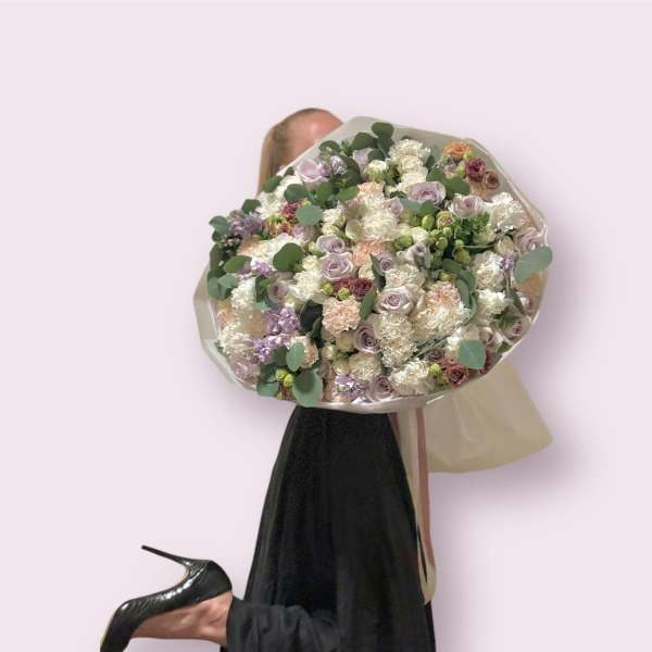 Beautiful and large bouquet of different flowers with the addition of greenery.