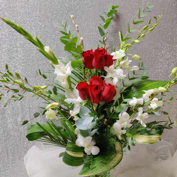 Red roses and white orchids in a glass vase