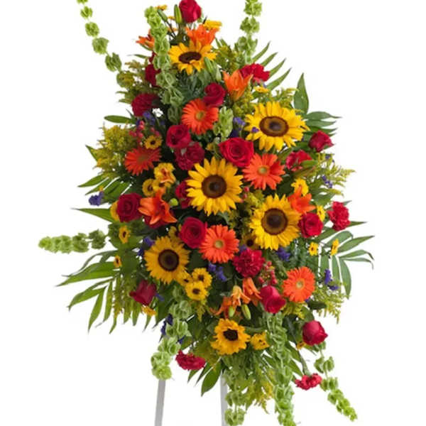 Large standing floral spray with sunflowers, red roses, and orange blooms