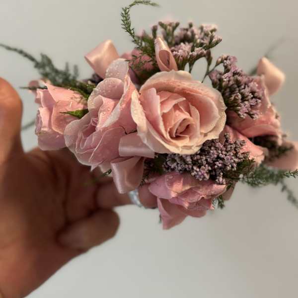 Small pink rose corsage with ribbon and tiny purple filler flowers