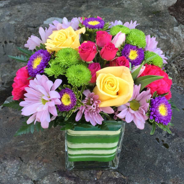 Mixed bouquet of roses and daisies in a striped glass vase