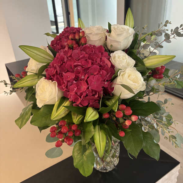 Bouquet of white roses and pink hydrangea in a glass vase