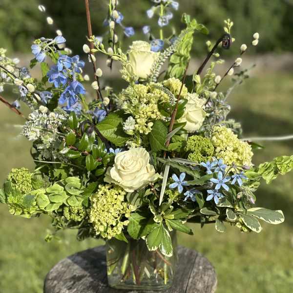 Blue and white floral arrangement in a clear glass vase