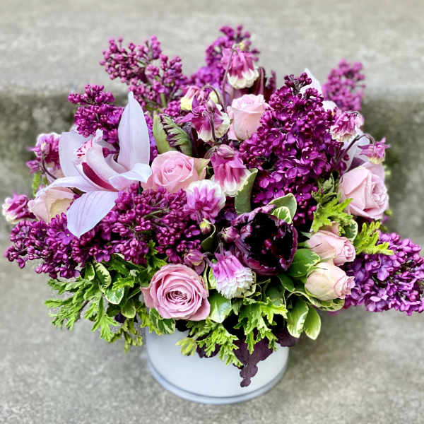 Pink and purple bouquet in a white container