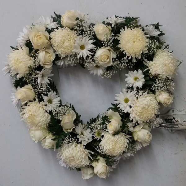 Heart-shaped white floral wreath with roses and daisies