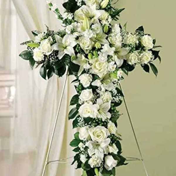 White floral cross arrangement on an easel