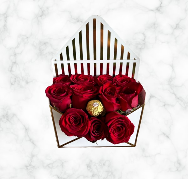 Red roses in a geometric gift box with a gold chocolate