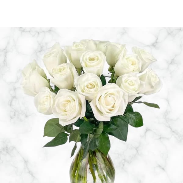 White roses arranged in a clear glass vase