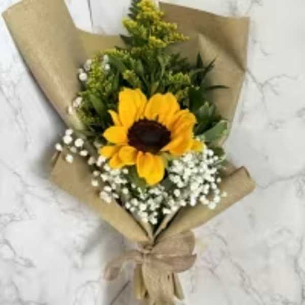 Sunflower bouquet wrapped in brown paper with white filler flowers