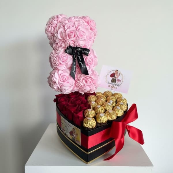 Pink rose teddy bear with red roses and gold chocolates in a heart-shaped box