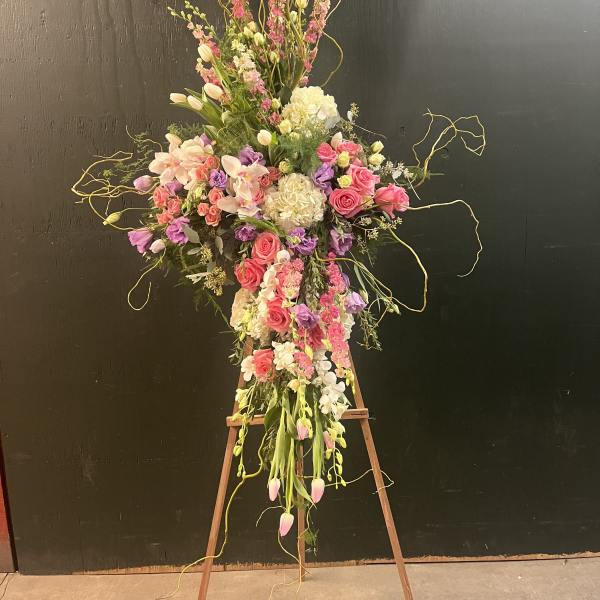 Tall floral spray with pink and white blooms on an easel