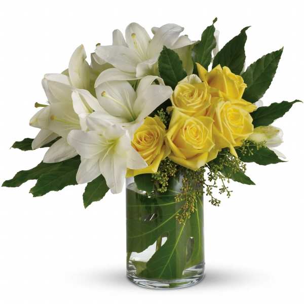 White lilies and yellow roses in a glass vase