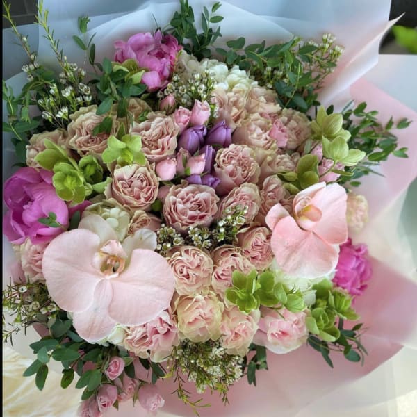 Bouquet of blush roses and pink orchids with greenery