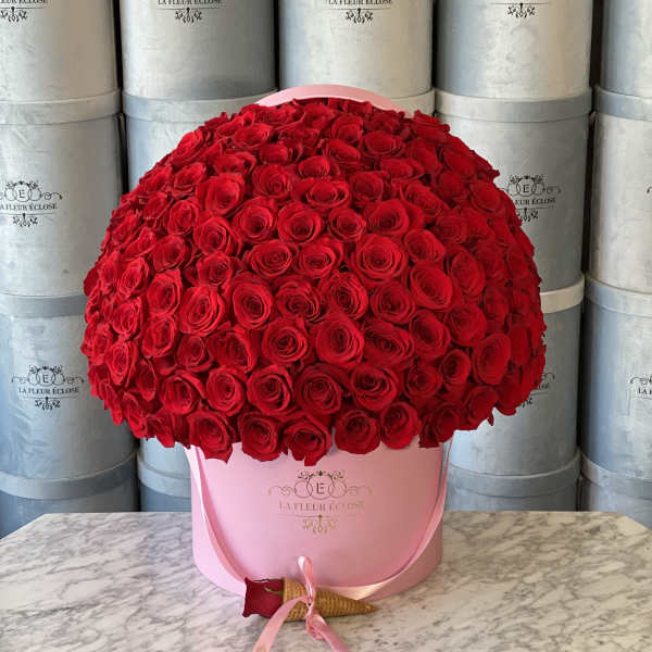 Large dome of red roses in a pink hatbox with ribbon