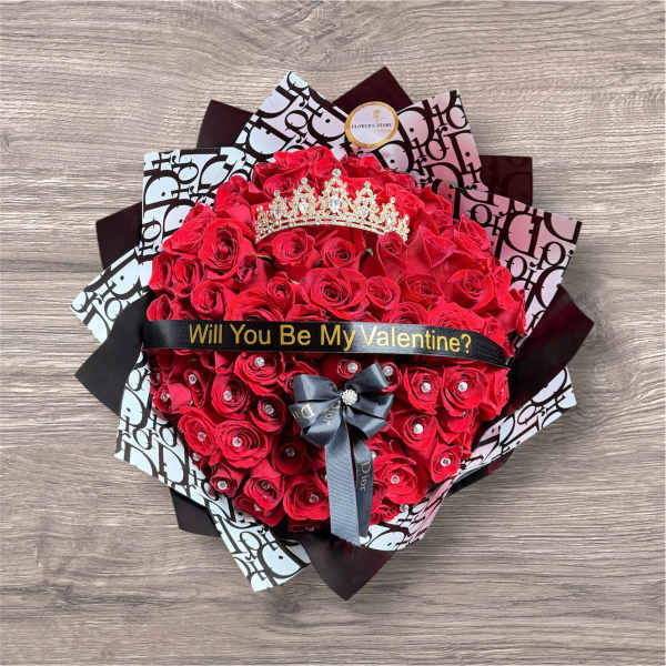 Heart-shaped bouquet of red roses with a tiara and ribbon