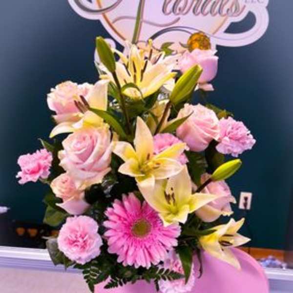 Pink and yellow floral arrangement in a pink Tiffany & Co. box with balloons
