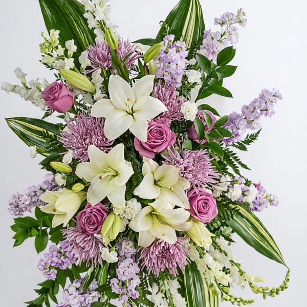 Tall floral spray with white lilies, pink roses, and lavender blooms