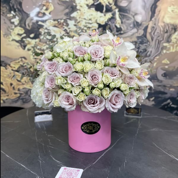 Pink and white rose arrangement in a pink cylindrical box with white orchids