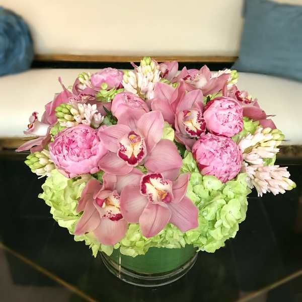 Pink and green floral arrangement in a glass bowl vase