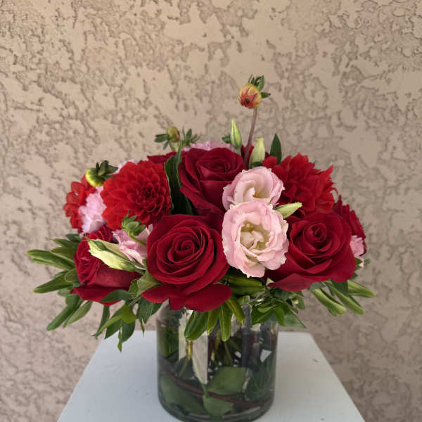 Red roses and pink lisianthus in a glass vase